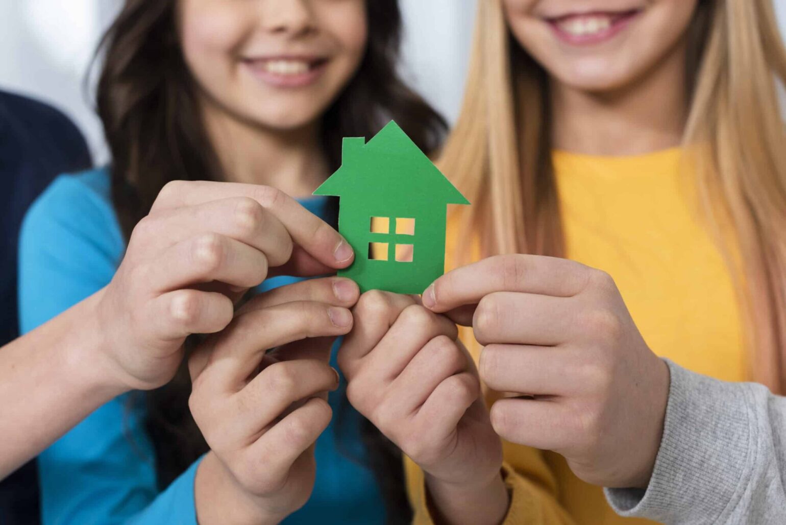 Close-up-kids-holding-toy-house-scaled